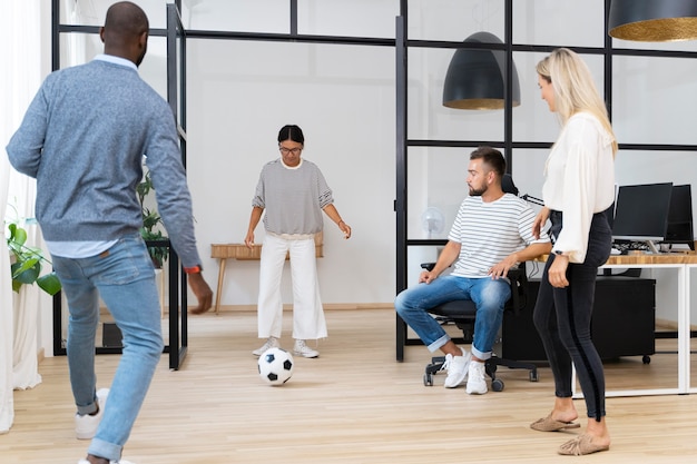 Kostenloses Foto junge leute spielen mit ball im büro