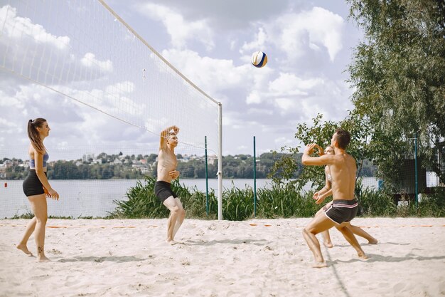 Junge Leute spielen Volleyball am Strand