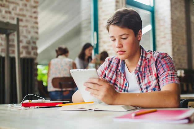 Junge liest mit Tablette