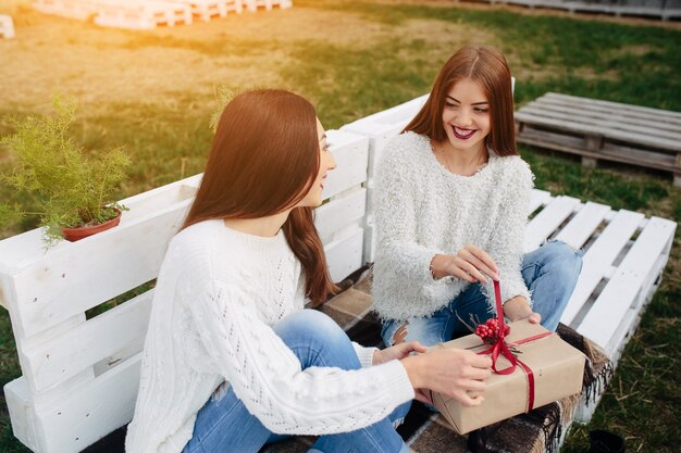 Junge Mädchen, die ein braunes Geschenk öffnen