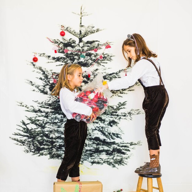 Junge Mädchen, die Weihnachtsbaum verzieren