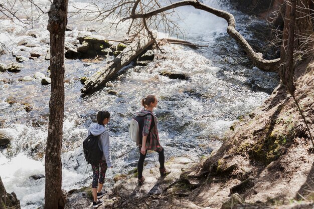 Junge Mädchen gehen auf Steine ​​am Fluss