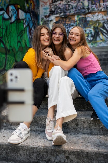 Junge Mädchen im Teenageralter nehmen Rollen von sich selbst im Freien für soziale Medien auf