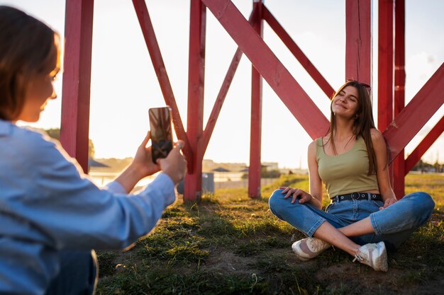 Junge Mädchen im Teenageralter nehmen Rollen von sich selbst im Freien für soziale Medien auf