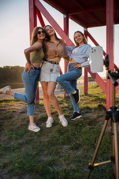 Junge Mädchen im Teenageralter nehmen Rollen von sich selbst im Freien für soziale Medien auf
