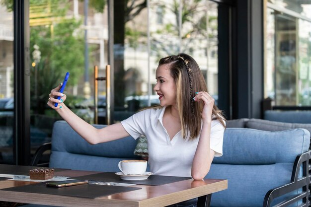 Junge Mädchen sitzen im Restaurant und machen Selfie