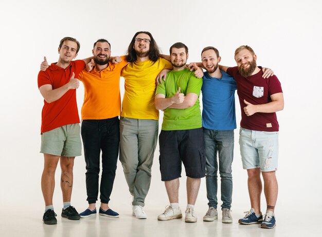 Junge Männer trugen in LGBT-Flaggenfarben lokalisiert auf weißer Wand