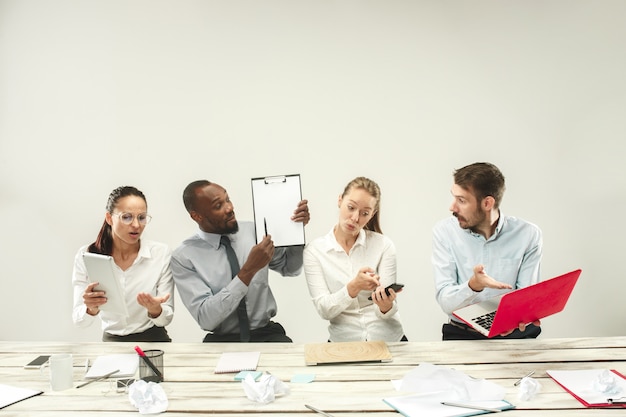 Junge Männer und Frauen sitzen im Büro und arbeiten an Laptops. Emotionskonzept