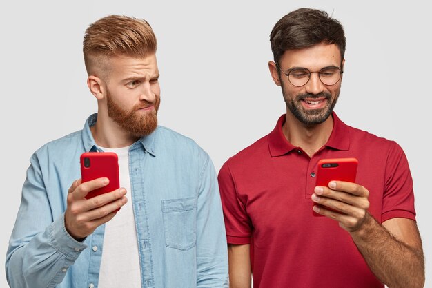 Junge männliche Blogger chatten online per Handy, ignorieren echte Live-Kommunikation, surfen im Internet