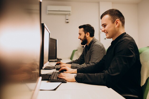 Junge männliche Webdesigner, die an einem Computer arbeiten