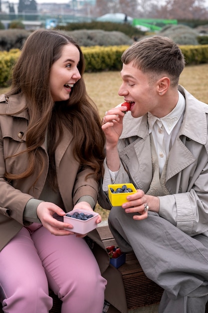 Kostenloses Foto junge menschen essen beeren auf der straße