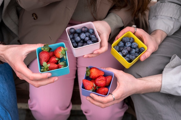 Kostenloses Foto junge menschen essen beeren auf der straße