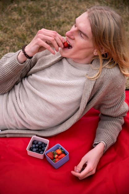 Kostenloses Foto junge menschen essen beeren auf der straße