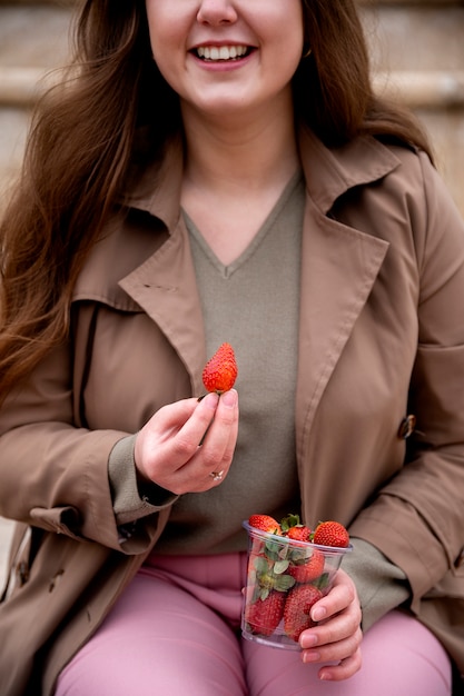 Kostenloses Foto junge menschen essen beeren auf der straße