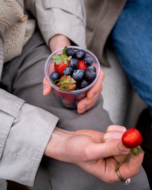 Kostenloses Foto junge menschen essen beeren auf der straße