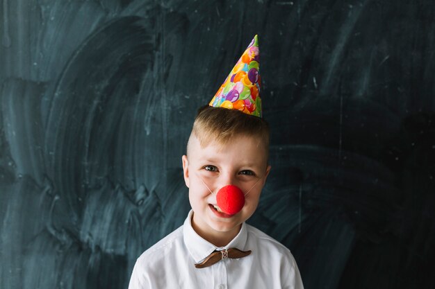 Junge mit Clownnase auf Geburtstagsfeier