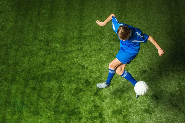 Junge mit dem Fußball, der fliegenden Tritt tut