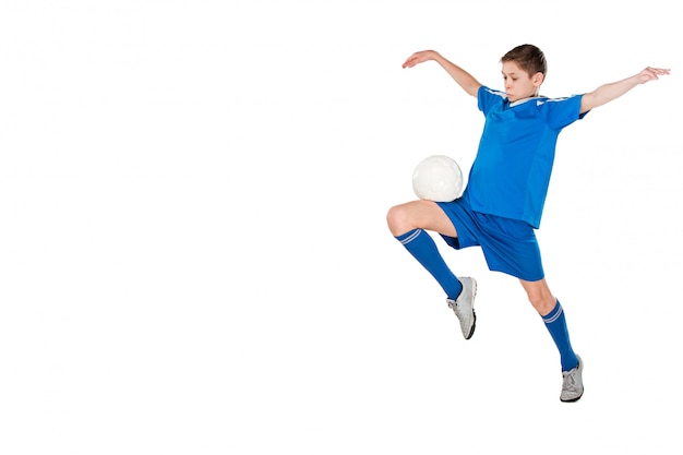 Junge mit dem Fußball, der fliegenden Tritt tut