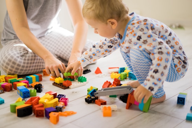 Junge mit der Mutter, die im bunten Baukasten spielt