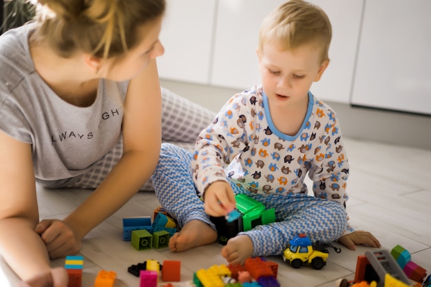 Junge mit der Mutter, die im bunten Baukasten spielt