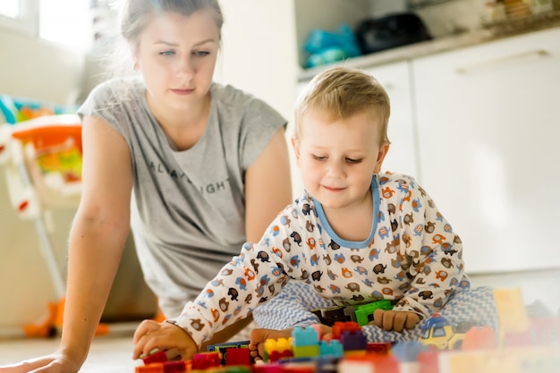 Junge mit der Mutter, die im bunten Baukasten spielt