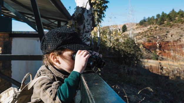 Junge mit fernglas am handlauf