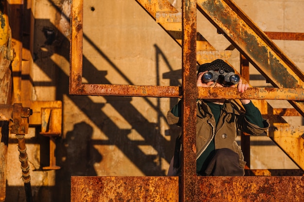 Junge mit Fernglas bei Treppen