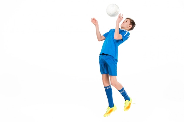 Kostenloses Foto junge mit fußball, der fliegenden tritt tut