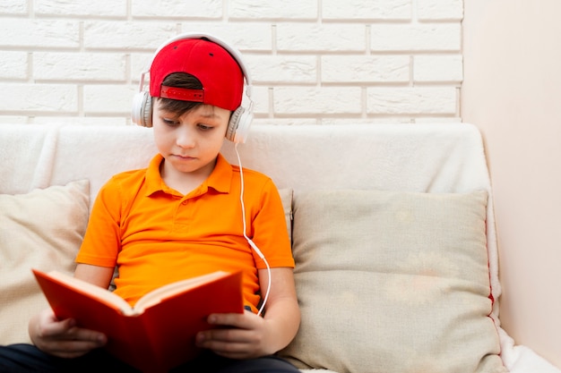 Junge mit Kopfhörern beim Lesen