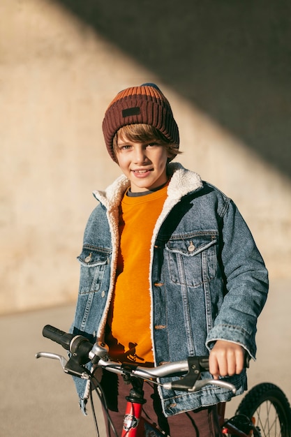 Junge mit seinem Fahrrad draußen in der Stadt, die Spaß hat