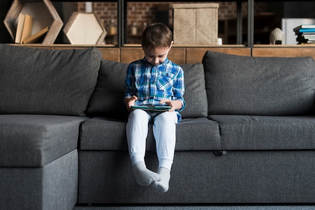 Junge mit Tablet auf der Couch