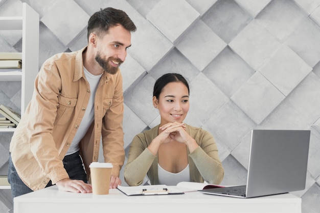 Junge mitarbeiter, die bei der arbeit zusammenarbeiten