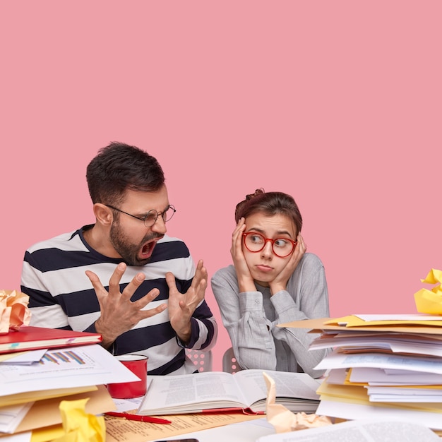 Junge Mitarbeiter sitzen am Schreibtisch mit Dokumenten