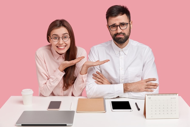 Junge Mitarbeiter sitzen am Schreibtisch mit Gadgets und Kalender