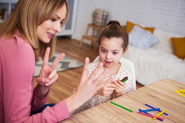 Junge Mutter bringt ihrem Kind zu Hause das Zählen bei