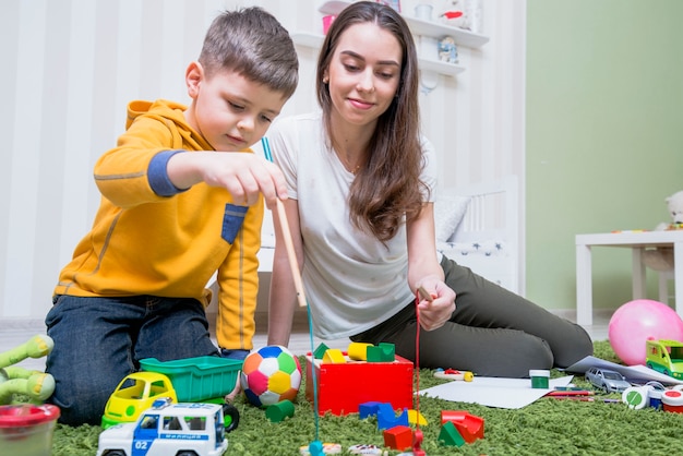 Junge Mutter, die mit Sohn spielt