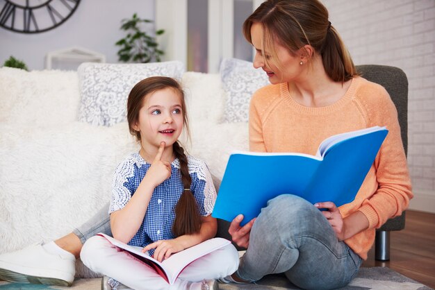 Junge Mutter hilft ihrer Tochter bei den Hausaufgaben