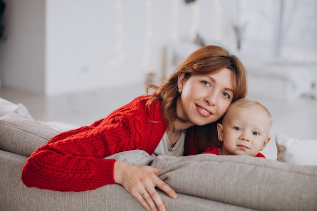 Junge Mutter mit ihrem kleinen Sohn, der auf Sofa sitzt