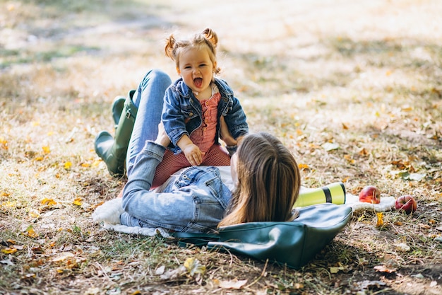 Junge Mutter mit ihrer kleinen Tochter in einem Herbstpark, der Picknick hat