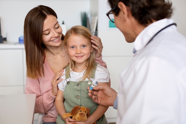 Junge Mutter mit ihrer Tochter beim Kinderarzt zur Beratung