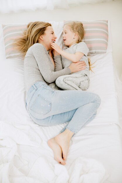 Junge Mutter und ihre kleine Tochter zu Hause am sonnigen Morgen