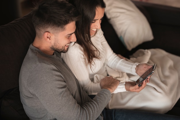 Kostenloses Foto junge paare des hohen winkels, die telefon überprüfen