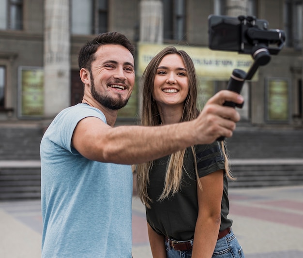 Junge Paare, die draußen ein selfie nehmen