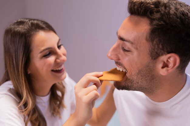 Junge Paare, die Frühstück im Bett essen