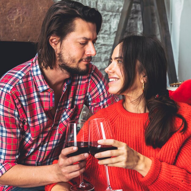 Junge Paare, die Gläser Wein klopfen