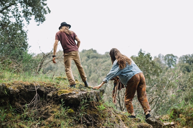 Kostenloses Foto junge paare, die im wald wandern