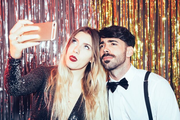 Junge Paare, die selfie auf Party der neuen Jahre nehmen