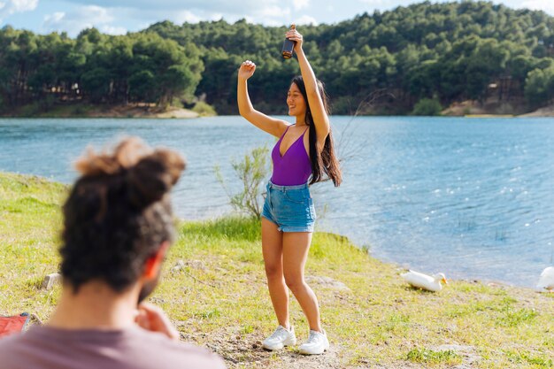 Junge Paare, die Spaß auf Flussufer haben