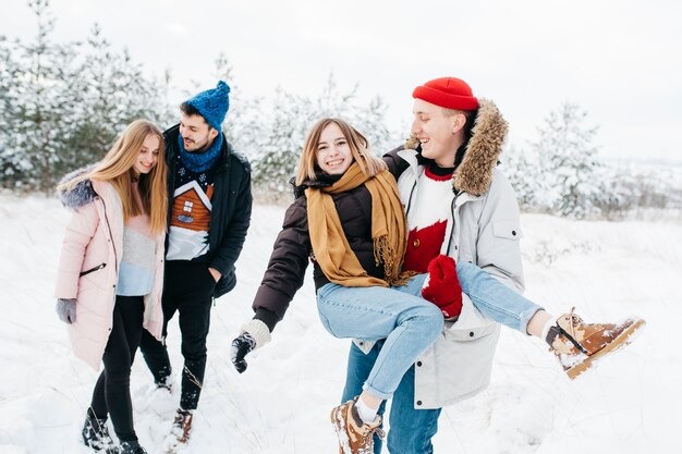 Junge Paare, die Spaß im Winterwald haben