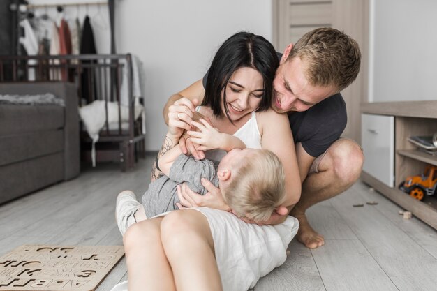 Junge Paare, die Spaß mit ihrem kleinen Sohn zu Hause haben